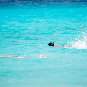 People snorkeling in bright turquoise water