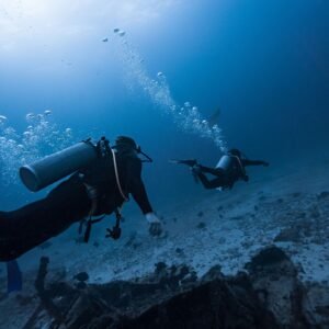 Divers navigating along a reef in clear water