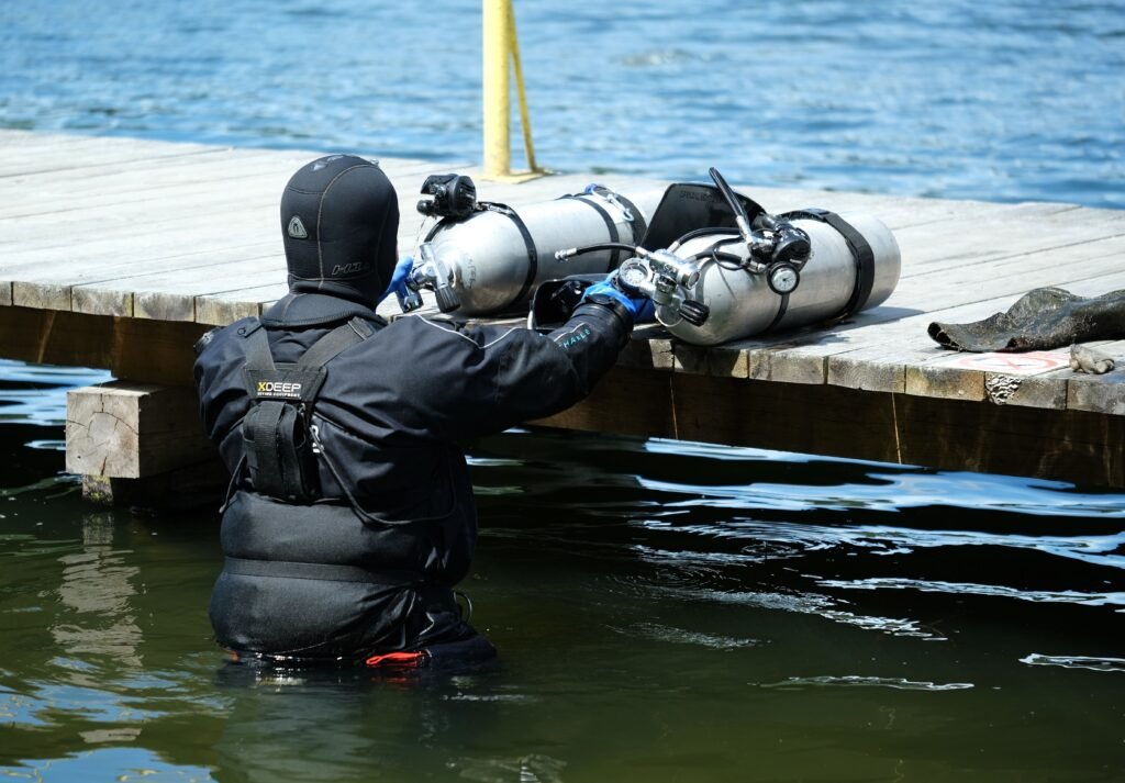 Scuba diver descending into deep blue water
